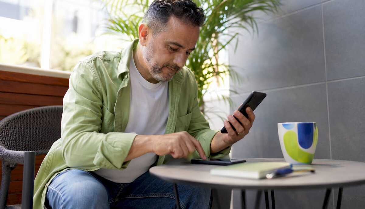 _Man-managing-dual-SIM-smartphone-settings-at-desk.jpg