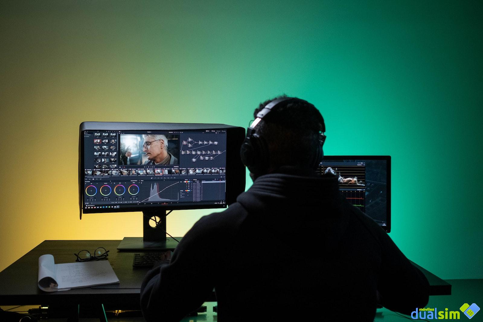A Man Sitting on Front of the Computer while Editing Video